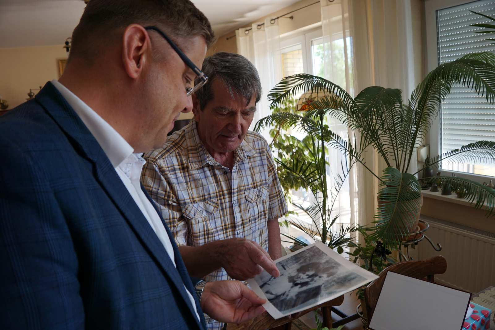 Mieszkaniec Skórzewa z Wójtem Gminy Dopiewo ogląda zdjęcia podczas Diamentowego Jubileuszu