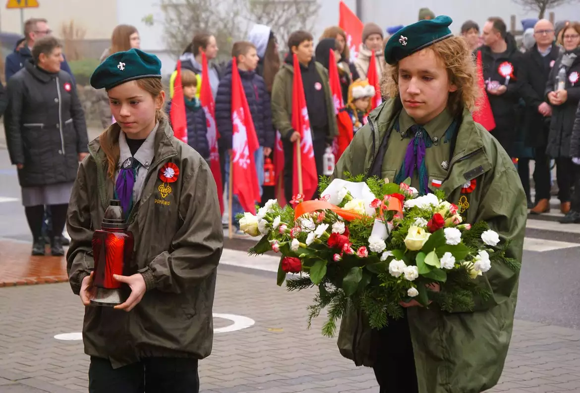 Harcerze składają kwiaty pod tablicą